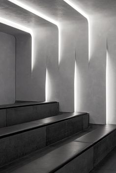 a black and white photo of some stairs in a building with light coming through the windows