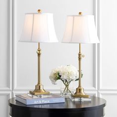 two lamps sitting on top of a table next to a vase with flowers in it