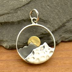 Salute the sun with this lovely necklace! A circle of sterling silver is filled with two mountains, one hammered and one oxidized, and a golden brass sun setting behind them. Sterling silver pendant and chain. Pendant is 5/8", on an adjustable 16-18" cable chain. Silver Mountain, Mountain Jewelry, Sun Rising, Travel Necklace, Mountain Necklace, Nature Necklace, Gold Sun, Travel Jewelry, Silver Pendants