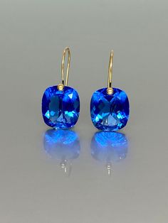 Gorgeous sparkly tanzanite drop earrings. The Faceted drops are flawless and eye-clean and have a beautiful vivid clear deep blue color. The drops are attached to 24K gold vermeil/14K SOLID GOLD / 18K SOLID GOLD  ear wires. The earrings are minimalist and elegant and have a luxurious look.  A truly gorgeous pair of earrings. When 14K SOLID GOLD ear wires are used, the ends are hand-stamped as proof of being 14K solid gold. In addition, extra work was done at the ends of the ear wires to prevent any sort of pain or injury while inserting them through the ear lobes. **The 14K WHITE solid gold ear wires are RHODIUM plated to prevent tarnish of the ear wires over time. * Quality: Superb AAA+  Flawless Faceted Tanzanite  * Carat (24 ct.) * Stone Shap: Cushion Cut Rectangle  * The dimension of s Tanzanite Drop Earrings, Cobalt Blue Earrings, Deep Blue Color, Celtic Earrings, Teal Earrings, Tanzanite Earrings, September Birthstone Jewelry, Coin Earrings, Birthstone Earrings