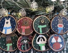 christmas ornaments are hanging on the tree in front of snowflakes and pine branches