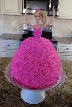 a barbie doll cake sitting on top of a counter