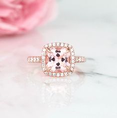 Beautiful Cushion Halo Morganite Ring ►Base metal: sterling silver (925) ►Plating: 14K Rose Gold ►Accented With Simulated Diamonds (CZ) Center Stone: Morganite Color: Peachy-Pink Shape: Cushion Measurements: 8.0 x 8.0 mm Carat Weight: 2.4 ct. (approx.) Gemstone creation: Lab-Created ►Please be aware that plated jewelry can wear off over time, if this is a concern we would suggest going with the sterling silver or solid gold jewelry option. ►Sterling silver ring version can be purchased here: htt Elegant Pink Ring For Anniversary, Elegant Pink Rings For Anniversary, Pink Diamond Promise Ring With Halo Design, Classic Morganite Diamond Ring For Wedding, Classic Morganite Diamond Wedding Ring, Classic Pink Halo Ring With Gemstone, Classic Morganite Cushion Cut Rings, Classic Pink Gemstone Halo Ring, Elegant Pink Diamond Ring For Anniversary