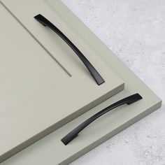 a pair of black handles sit on top of a gray countertop next to a white door