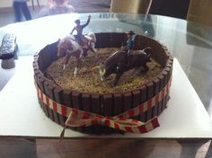 there is a chocolate cake decorated with toy horses and men riding on top of it