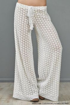 the woman is wearing white crochet pants