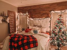 a bedroom decorated for christmas with lights on the headboard and tree in the corner