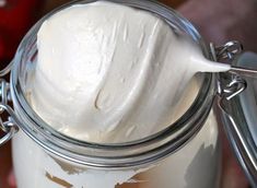 a glass jar filled with whipped cream on top of a table