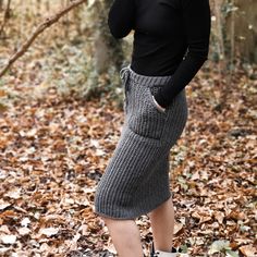 a woman is standing in the leaves with her hands on her hips