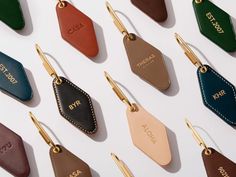 leather luggage tags with the names of different types and colors are shown on a white surface