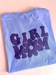 Girl Mom Tee  Design on a Comfort Colors Violet tee with Purple puff print on the front and back.  Design  Front: Flower Back: Girl Mom phrase  Comfort Color Puff tees unisex fit - runs true to size. For an oversized look size up one size.  Made to order  Super comfortable, soft and fashionable, to enjoy the best role of our lives: BEING MOM! Care Instructions  Given the nature of the design and the type of vinyl used, follow these instructions to extend the life of your garment:  * Wash in cold Blue Text Print T-shirt For Mother's Day, Fun Graphic Print Top For Mother's Day, Purple Slogan Tops, Cute Graphic Print T-shirt For Mother's Day, Cute Mother's Day Graphic Print T-shirt, Cute Mother's Day T-shirt With Graphic Print, Cute Slogan Tops For Mother's Day, Blue Graphic Print Top For Mother's Day, Purple Cotton T-shirt With Custom Print