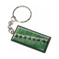 a green keychain with some black and white designs on the front of it