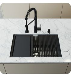 a kitchen sink with a black faucet over it next to a white counter top