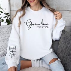 "Celebrate the special bond between a Grandmother and her grandchildren with our unique Personalized Grandma sweatshirt. This sweatshirt can be personalized with the grandmother's nickname (Gigi, Mimi, Nana, Grandma, Abuela, Lolli, etc.), her special EST date, and the name of her grandchildren making it an extra special gift that she will remember forever.  Enter the name you would like (see picture #6 for options), the year, and the name(s) you would like printed in the personalization box and White Long Sleeve Sweater With Name Print, Personalized White Sweatshirt For Family Matching, White Relaxed Fit Sweatshirt For Family Matching, Personalized White Tops For Winter, Personalized White Long Sleeve Tops, Personalized Long Sleeve White Tops, Long Sleeve Tops With Name Print For Family, Family Matching White Long Sleeve Sweatshirt, White Long Sleeve Family Matching Sweatshirt