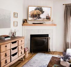 a living room with a fire place and a painting on the fireplace mantel above it