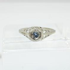 a ring with a blue stone in the center on a clear display case for sale