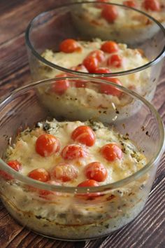 three glass bowls filled with food on top of a wooden table