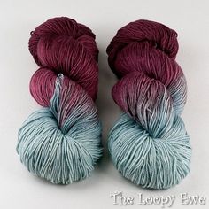 two skeins of yarn are sitting next to each other on a white surface