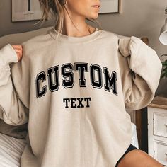 Custom Text Sweatshirt Vintage College Letters Sweatshirt Gift Retro Oversized Sweater Personalized Add Your Own Text Custom Quote Varsity Plus sizes also available: 2X, 3X, 4X, 5X -------- HOW TO ORDER -------- 1) Select your sweatshirt Size 2) Select your desired Color 3) Add personalization. 4) Click "Add to Cart" and place your order. 5) Repeat for more items. Ideal for any situation, a unisex heavy blend crewneck sweatshirt is pure comfort. These garments are made from polyester and cotton. Oversized T-shirt With Ribbed Cuffs For College, Oversized Collegiate Sweatshirt For College, Oversized Collegiate Hoodie With Crew Neck, Customizable Varsity Tops For Streetwear, Oversized T-shirt For College, Oversized Varsity College Sweats, Oversized Varsity Sweats For College, Custom Text Long Sleeve Tops For Streetwear, Casual Black Sweatshirt With Custom Text