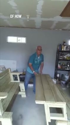 a man standing next to two wooden benches in a room that is being remodeled with paint on the walls