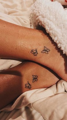 two people with matching tattoos on their legs laying in bed next to eachother