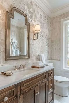 a bathroom with two sinks, a toilet and a large mirror above the sink in it