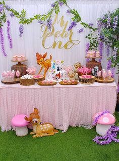 a table topped with lots of cakes and cupcakes