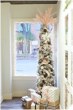 a decorated christmas tree in front of a window