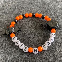 "Show your Halloween spirit with this quirky bracelet! It is made with black and orange ball shaped beads, a black bat, a black cat and white and black letter beads. Cat and bat both measure about 1\"." Adjustable Black Bracelets For Halloween, Halloween Novelty Black Bracelets, Novelty Black Beaded Bracelets For Halloween, Casual Black Bracelets For Halloween, Halloween Black Bracelets With Round Beads, Halloween Black Adjustable Beaded Bracelets, Black Round Bead Bracelets For Halloween, Black Stretch Bracelet With Round Beads For Halloween, Black Round Beaded Bracelets For Halloween