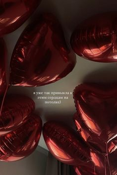 red heart shaped balloons hanging from the ceiling in a room with a quote on it