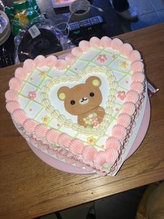 a heart shaped cake with a teddy bear on it