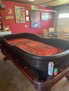 a pool table that has been painted red and black with some stickers on it