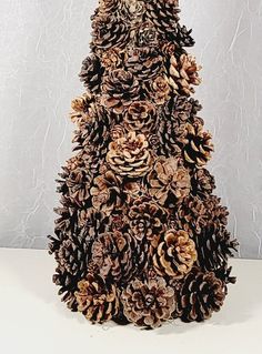 a very tall christmas tree made out of pine cones