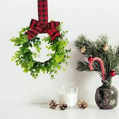 a christmas wreath and candle are sitting next to each other