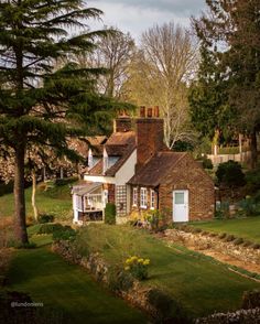 a brick house surrounded by trees and grass