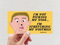 a person holding up a sticker with the words i'm not picking my nose