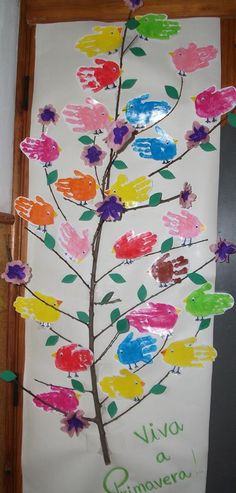 a child's handprinted tree is displayed in front of a wall hanging