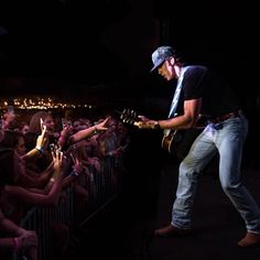 a man playing guitar in front of an audience