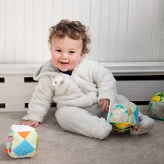 a baby sitting on the floor with stuffed animals