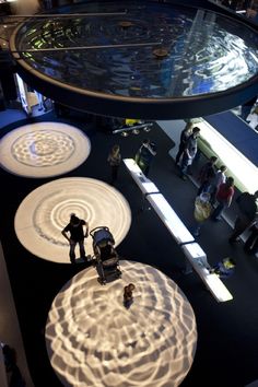 an overhead view of people standing in front of art work on display at a museum