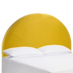 a yellow headboard with white sheets and pillows