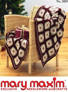 a crocheted blanket on a chair next to a christmas tree