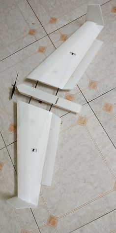 two pieces of white plastic sitting on top of a tiled floor