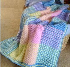 a crocheted blanket sitting on top of a basket