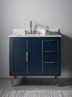 a bathroom vanity with marble top and blue cabinet