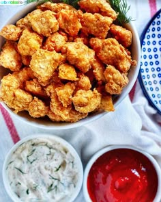 a bowl filled with tater tots next to dips and ketchup