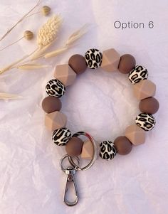 a brown and white bracelet with leopard print beads on it, sitting next to a dried plant