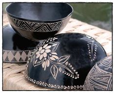 three black and white bowls sitting on top of a table next to eachother