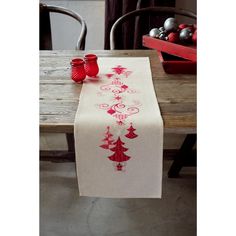 the table runner is decorated with red and white christmas trees