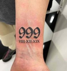 a wrist tattoo with the number 999 written in roman numerals on it